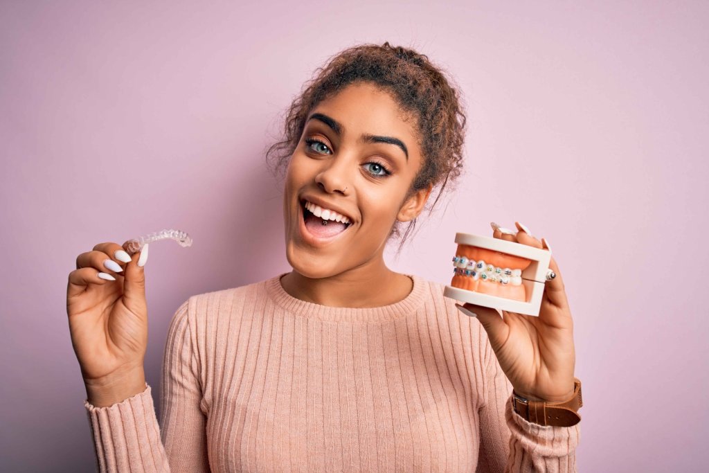girl holding clear aligners